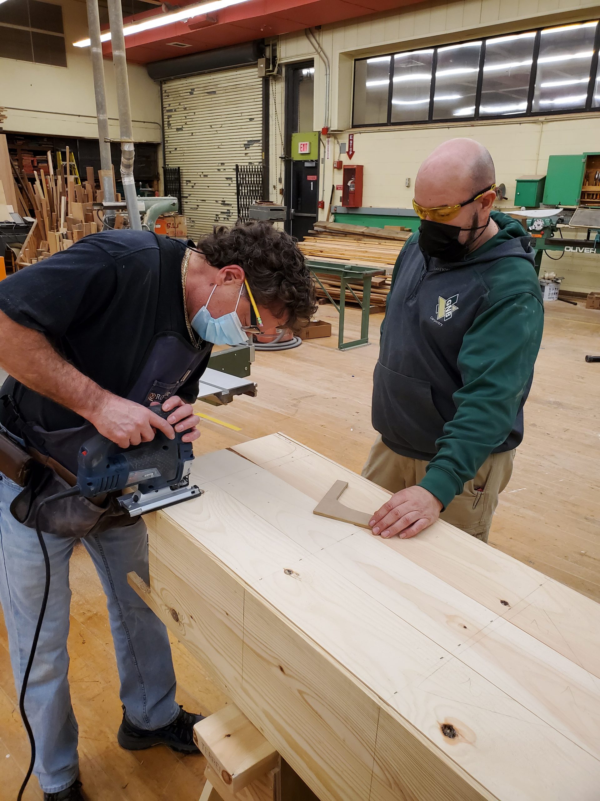 fine woodworking class man works on cutting a table with the instructor
