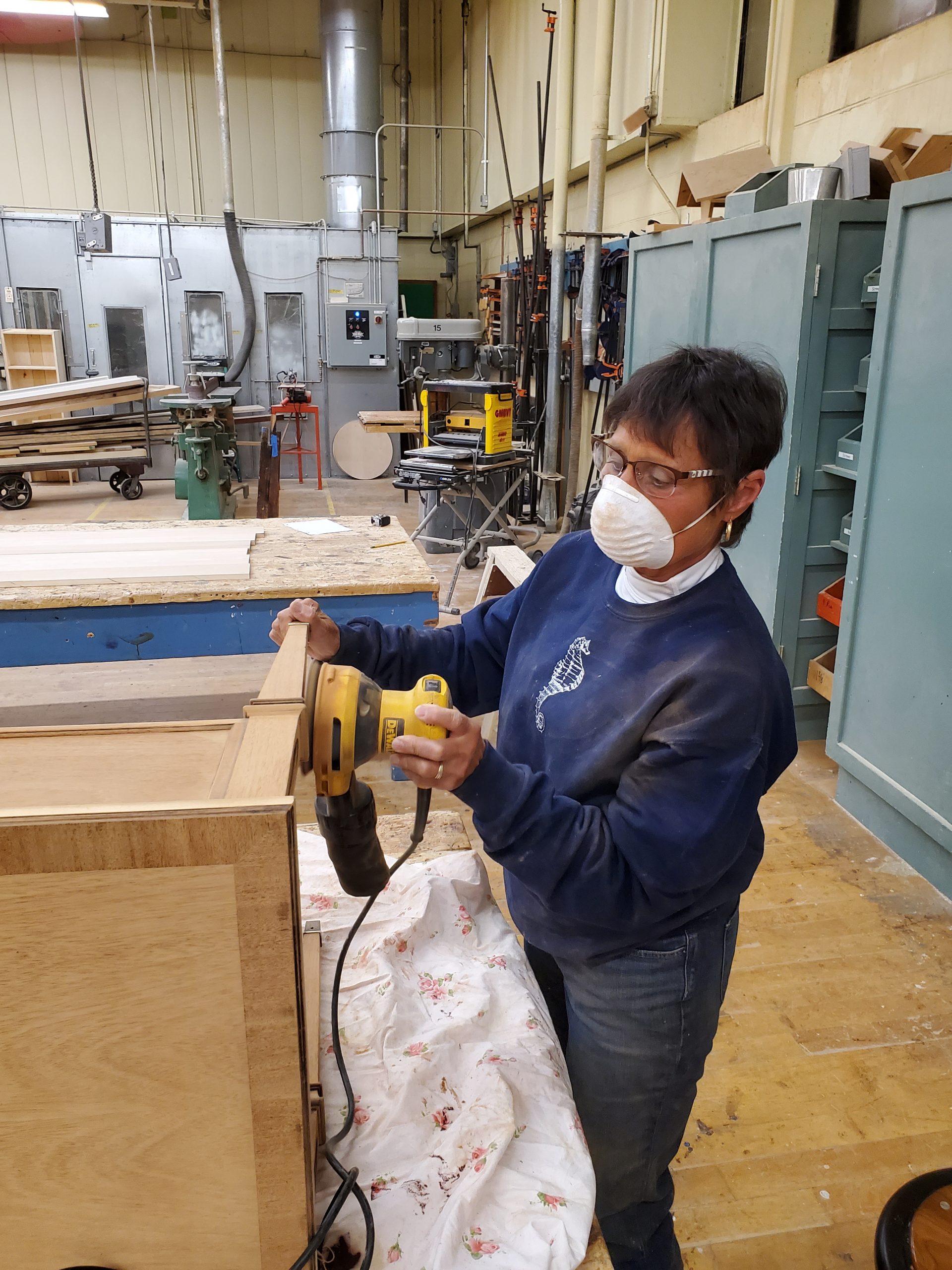 Furniture refinishing woman sands a table