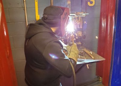In Arc Welding, a student is welding and sparks are flying